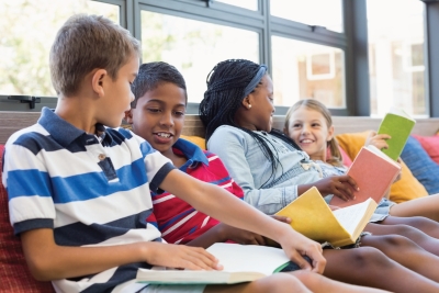Group of preteens chatting and reading books