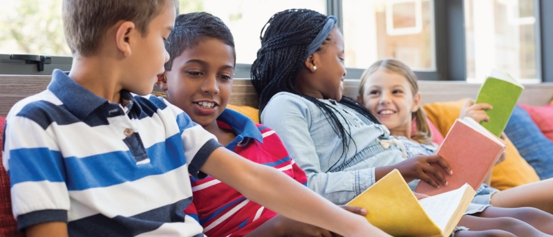 Group of preteens chatting and reading books