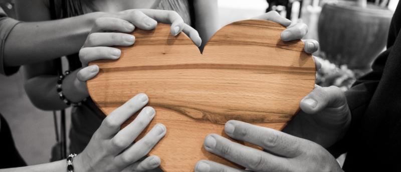 Hands holding a wooden heart